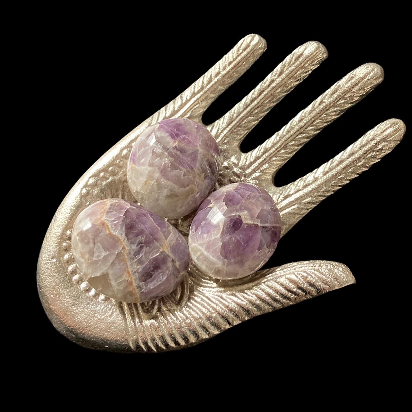 Three amethyst palm stones in hand display